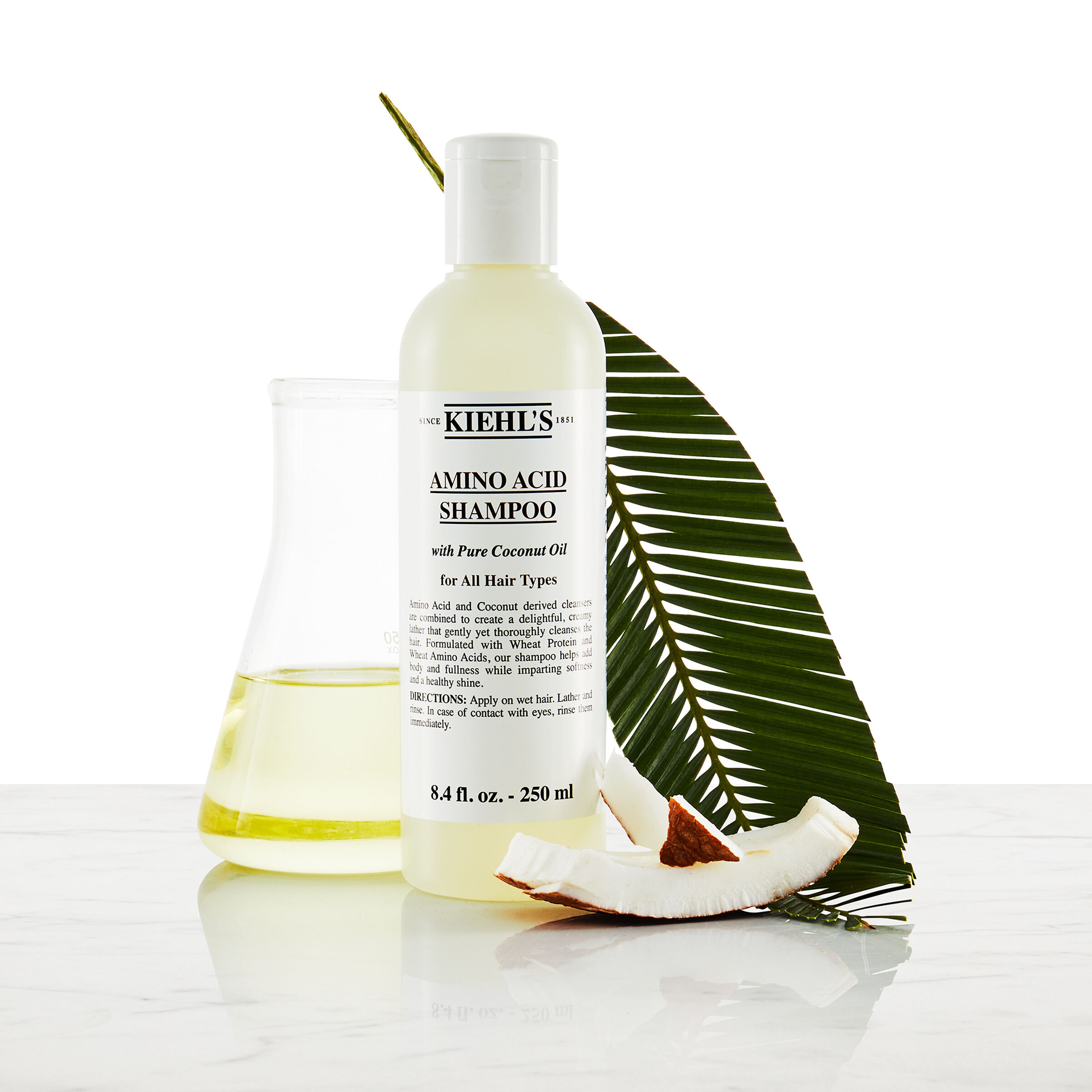 Model sa brkovima i bočicom Kiehl's Amino Acid šampona