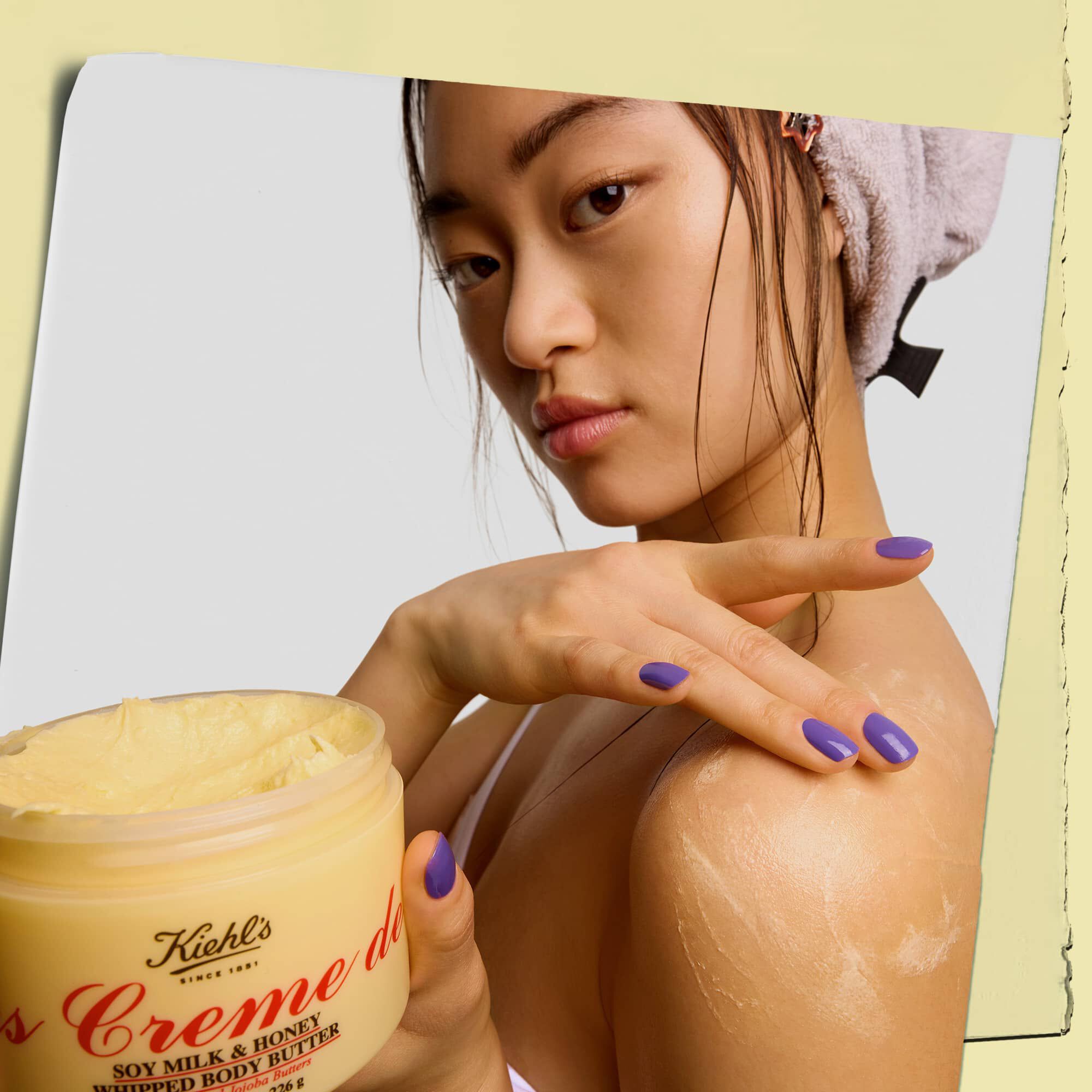 Model drži posudicu i nanosi maslac za telo Kiehl's Creme de Corps Whipped Butter