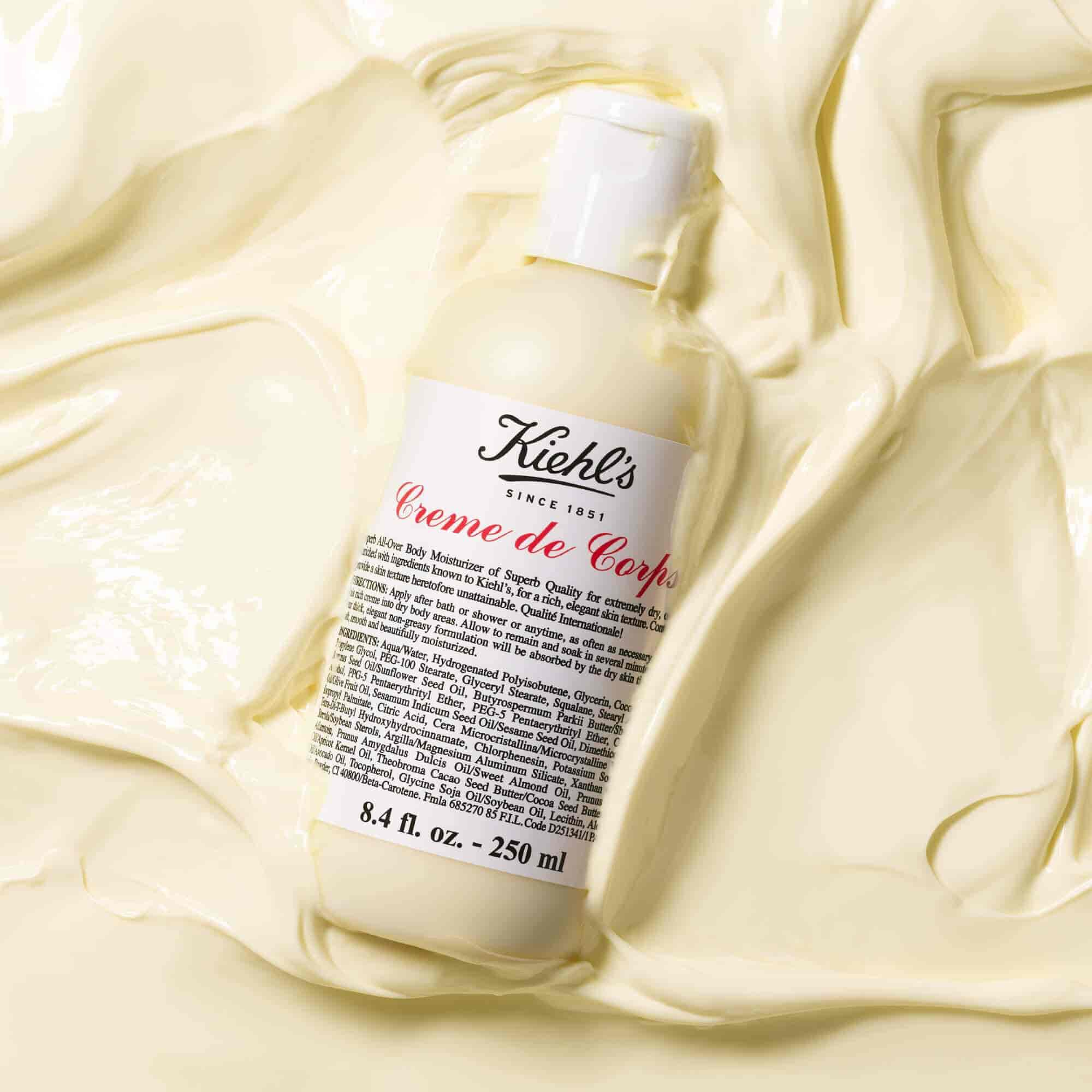 Bočica Kiehl's Creme de Corps u velikoj količini teksturiranog losiona za telo