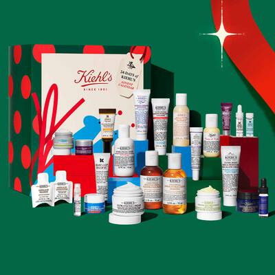 Kiehl's praznični adventski kalendar i poklon set za negu kože s raznim kremama, serumima, sredstvima za čišćenje i tretmanima na svečanom postolju.