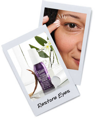 A close-up of a woman applying eye serum from Kiehl's, emphasizing the product for restoring eye appearance.
